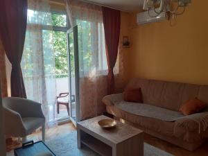 a living room with a couch and a window at Apartman Sunce in Podgorica