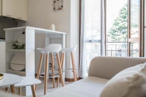 two white stools in a living room with a couch at "Le Charmant" - CIR VDA-SAINT-VINCENT-n 0004 in Saint Vincent