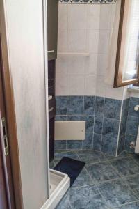 Łazienka z prysznicem wyłożona jest niebieskimi kafelkami. w obiekcie "Le Charmant" - CIR VDA-SAINT-VINCENT-n 0004 w mieście Saint Vincent