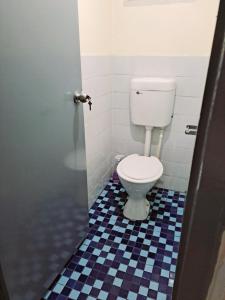 ein Badezimmer mit einem WC und einem blauen und weißen Fliesenboden in der Unterkunft Town Centre Stays in Nadi