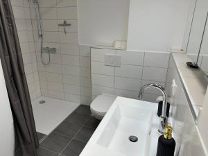 a bathroom with a sink and a shower and a toilet at SUITE4ME - Balkon I Küche I Waschmaschine I Mainz-Kostheim in Wiesbaden