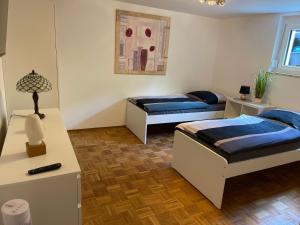 Zimmer mit 2 Betten und einem Tisch mit einer Lampe in der Unterkunft Cal-ifornia Home 2 in Nürnberg