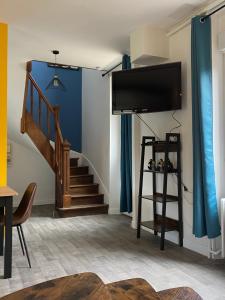 uma sala de estar com uma escada e uma televisão de ecrã plano em Maison les 3 fées , 3 chambres, Chamerolles em Courcy-aux-Loges