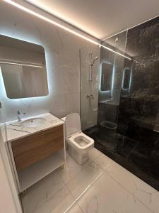 Comfort Hotel في ستروغا: حمام مع مرحاض ومغسلة ودش