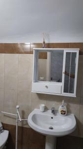 un bagno con un lavandino bianco e uno specchio di Dimora Santa Chiara a Manfredonia Altre 7 foto