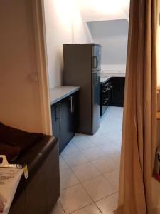 a living room with a couch and a refrigerator at T2 à 9 mins du château 4pers in Le Chesnay
