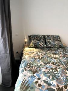 1 dormitorio con 1 cama con edredón de flores en Le 20 La Loire Maison de bord de Loire, en Chalonnes-sur-Loire