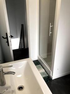 y baño con lavabo blanco y ducha. en Le 20 La Loire Maison de bord de Loire, en Chalonnes-sur-Loire