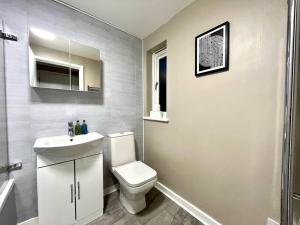 a bathroom with a white toilet and a sink at Fab Oxford City Centre Apartment sleeps 6 with in Oxford