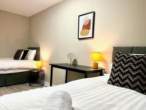 a bedroom with two beds and a desk in it at Fab Oxford City Centre Apartment sleeps 6 with in Oxford
