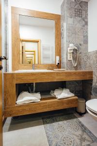La salle de bains est pourvue d'un lavabo et d'un miroir. dans l'établissement Blumenhof Bucovina, à Voroneț