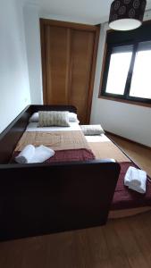 Cette chambre comprend un grand lit et une fenêtre. dans l'établissement Apartamento terra1, à Caldas de Reis