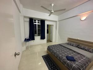 um quarto com uma cama e uma ventoinha de tecto em D'CAMERON MUSLIM HOMESTAY em Brinchang