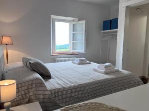 een slaapkamer met een groot bed en handdoeken bij Il Gessetto di Monteverdi Marittimo, Borgo di Canneto in Canneto