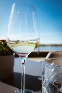 een glas witte wijn zittend op een tafel bij Hotel Rheinpromenade8 in Emmerich