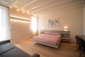 um quarto com uma cama, uma mesa e um sofá em Calcirelli Suites em Verona