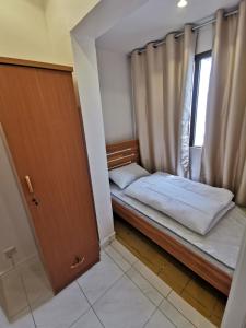 a small bedroom with a bed and a window at Cloud9 Premium Hostel in Dubai