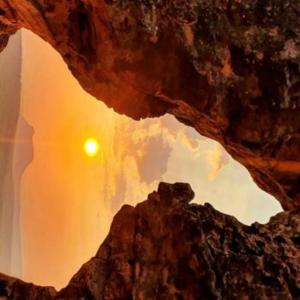 a view of a cave with the sun in the background at Pousada águas belas in Carolina