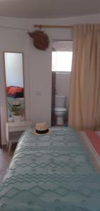a hat sitting on top of a bed in a bedroom at Cantinho dos moinhos in Figueira da Foz