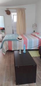 Un dormitorio con 2 camas y una mesa con sombrero. en Cantinho dos moinhos, en Montemor-o-Velho