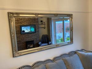 uno specchio a parete con divano e camino di Eclectic Bungalow Parking Nr Beach a Kent