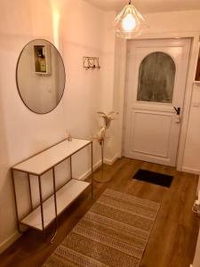 een kamer met een tafel, een spiegel en een deur bij L’oasis spa in Quiévrechain