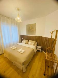 a bedroom with a large bed and a wooden chair at L’oasis spa in Quiévrechain