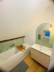 een witte badkamer met een bad en een wastafel bij L’oasis spa in Quiévrechain