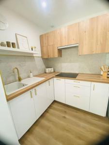 a kitchen with white cabinets and a sink at L’oasis spa in Quiévrechain