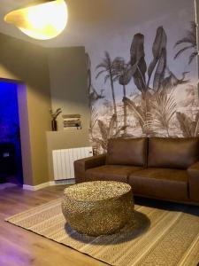 a living room with a couch and a coffee table at L’oasis spa in Quiévrechain