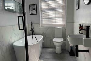 a bathroom with a tub and a toilet and a sink at Old Town Retreat, Grade Ii Listed, Margate Kent in Kent