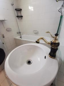 a bathroom with a white sink with a gold faucet at Cloud9 Premium Hostel in Dubai