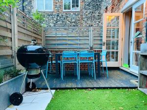 a grill on a deck with chairs and a table at Old Town Retreat, Grade Ii Listed, Margate Kent in Kent
