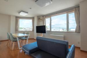 ein Wohnzimmer mit einem Sofa und einem Tisch in der Unterkunft Ezo Fujiya Niseko House - Vacation STAY 14767 in Kutchan