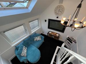 The Old Fishing Store - Sauna, Tech & No Guest Fee في Kent: غرفة معيشة مع أريكة زرقاء وتلفزيون