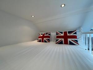 a bedroom with a bed with british flag pillows at The Old Fishing Store - Sauna, Tech & No Guest Fee in Kent