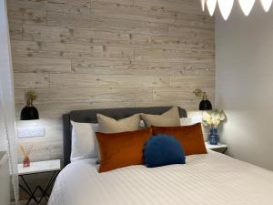 a bedroom with a white bed with a wooden wall at The Panoramic - Beach Front Apt - No Guest Fees in Kent