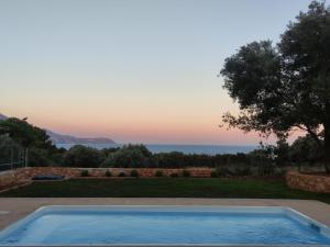 a villa with a swimming pool and a view of the ocean at Villa Ruby in Pesádha