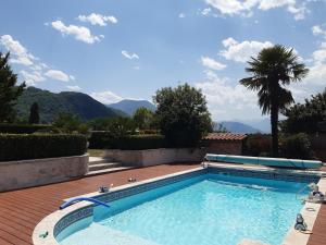 a swimming pool with mountains in the background at Un petit coin de paradis à Haute Jarrie in Jarrie