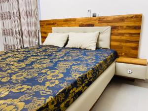 Abomey-CalaviにあるEspace Scycaのベッドルーム1室(木製ヘッドボード付きのベッド1台付)