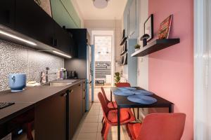a kitchen with pink walls and a table and chairs at Short Trips Apartment in Budapest