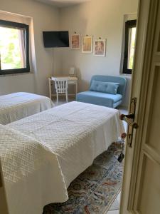 a room with two beds and a couch and a television at Casale la Civetta in Larino