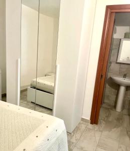 a bedroom with a mirror and a bed and a sink at Casa Funtana e Susu in Jerzu
