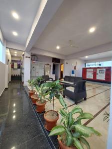 a lobby with a waiting room with potted plants at LK GRAND HOME in Tirupati