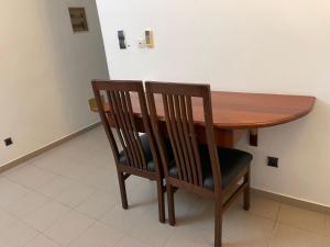 een houten tafel met 2 stoelen en een houten tafel bij Espace Scyca in Abomey-Calavi