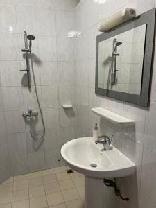 een witte badkamer met een wastafel en een douche bij Espace Scyca in Abomey-Calavi