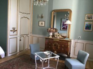 um quarto com um espelho e duas cadeiras e uma mesa em L’orangerie du Général em Saint-Jean-dʼAngély