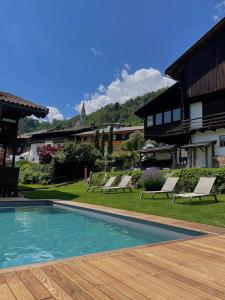 a pool with lounge chairs next to a building at Pension Moarhof in Feldthurns