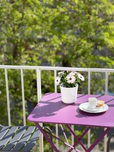 einen lila Tisch mit einem Blumentopf und einer Tasse Kaffee in der Unterkunft Maison Dormoy in Marseille