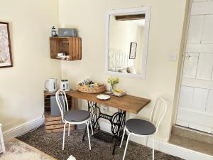 CaerswsにあるY Felin Bed and Breakfast and Smallholdingのテーブル、椅子2脚、鏡が備わる客室です。